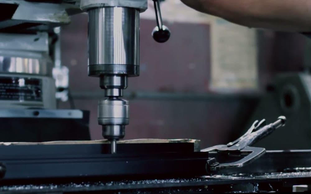 Drilling a clamped workpiece on a manual mill, quill fed by hand.